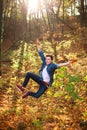 Young funny and curious handsome man jumping in forest park, lifestyle and freedom concept