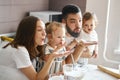 Young funny family blowing flour in the kitchen