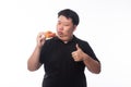 Young Funny Fat Asian man eating hawaiian pizza and showing thumbs up isolated on white background, Unhealthy concept. Royalty Free Stock Photo