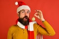 Young funny guy with red santa hat and Christmas ball Royalty Free Stock Photo