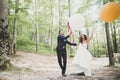 Young funny happy wedding couple outdoors with ballons Royalty Free Stock Photo