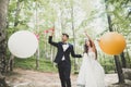 Young funny happy wedding couple outdoors with ballons Royalty Free Stock Photo