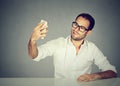 Young funny looking man taking pictures of him self with smart phone Royalty Free Stock Photo