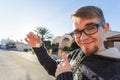 Young funny man holding house keys on house shaped keychain in front of a new home. Royalty Free Stock Photo