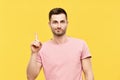 Young funny man pointing his finger up indicates to copy space isolated on yellow background Royalty Free Stock Photo