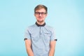 Young funny man wears spectacles isolated over blue background. Bearded wonk looks happy.