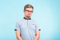 Young funny man wears spectacles portrait isolated over blue background. Bearded wonk looks happy.