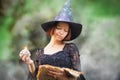Young funny witch casting spell, green fog aroung her, halloween consept
