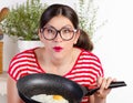 Young funny woman holding pan with egg Royalty Free Stock Photo