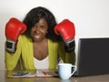 Young furious and angry afro american business woman in boxing gloves stressed by office computer desk work and negotiation fights Royalty Free Stock Photo
