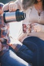 Young future parents and their dog in a funny costume sitting on a wooden bridge and having picnic near lake Royalty Free Stock Photo