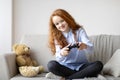 Teen girl playing a video game with controller