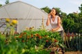 Young gardener in garden smelling flower Royalty Free Stock Photo