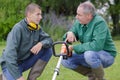 young gardener being shown how to operate strimmer Royalty Free Stock Photo