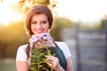 Young gardener in her garden holding flowers, sunny nature Royalty Free Stock Photo