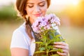 Young gardener in her garden holding flowers, sunny nature Royalty Free Stock Photo