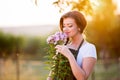 Young gardener in her garden smelling flowers, sunny nature Royalty Free Stock Photo