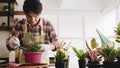 Gardener man disking soils in flowerpot in the room Royalty Free Stock Photo