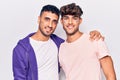 Young gay couple drawing rainbow lgtbq flag on face with a happy and cool smile on face