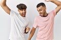 Young gay couple standing over isolated background dancing happy and cheerful, smiling moving casual and confident listening to Royalty Free Stock Photo