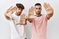 Young gay couple standing over isolated background doing frame using hands palms and fingers, camera perspective Royalty Free Stock Photo