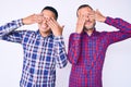 Young gay couple of two men wearing casual clothes covering eyes with hands smiling cheerful and funny Royalty Free Stock Photo