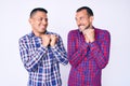 Young gay couple of two men wearing casual clothes laughing nervous and excited with hands on chin looking to the side Royalty Free Stock Photo