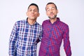 Young gay couple of two men wearing casual clothes looking at the camera blowing a kiss on air being lovely and sexy Royalty Free Stock Photo