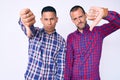 Young gay couple of two men wearing casual clothes looking unhappy and angry showing rejection and negative with thumbs down Royalty Free Stock Photo