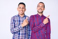 Young gay couple of two men wearing casual clothes smiling and looking at the camera pointing with two hands and fingers to the Royalty Free Stock Photo