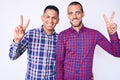 Young gay couple of two men wearing casual clothes smiling looking to the camera showing fingers doing victory sign Royalty Free Stock Photo