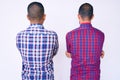 Young gay couple of two men wearing casual clothes standing backwards looking away with crossed arms Royalty Free Stock Photo