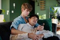 Young gay couple using mobile phone while embracing on sofa at home Royalty Free Stock Photo