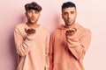 Young gay couple wearing casual clothes looking at the camera blowing a kiss with hand on air being lovely and sexy Royalty Free Stock Photo