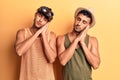 Young gay couple wearing summer clothes sleeping tired dreaming and posing with hands together while smiling with closed eyes Royalty Free Stock Photo