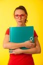 Young geek woman in red t shirt over vibrant yellow background