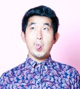 Young Geeky Asian Man in colorful shirt pulling funny face