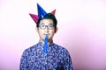 Young Geeky Asian Man wearing many party hats