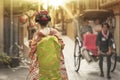 Young geisha walking in an alley of Kyoto in the sunset light. Royalty Free Stock Photo