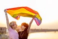 Young gender fluid couple in love waving a rainbow flag Royalty Free Stock Photo