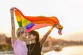 Young gender fluid couple in love waving a rainbow flag Royalty Free Stock Photo