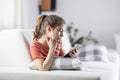 Young generation always on their phones represented by a girl at home with a cellphone in her hand Royalty Free Stock Photo