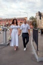 A young gentle couple walks through the city and enthusiastically discusses something. The beautiful bride and groom Royalty Free Stock Photo