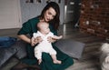 A young gentle happy mother hugs her newborn baby, smiling, sitting at home on the couch. Royalty Free Stock Photo