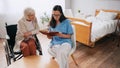 young geriatrician reading book to aged