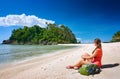 Young gerl with backpack relaxing on coast and looking to a isla Royalty Free Stock Photo