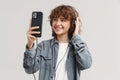 Young ginger joyful woman listening music with headphones and cellphone Royalty Free Stock Photo