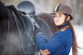 Young girl adjusting stirrups before riding horse