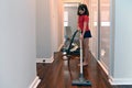 Young girl helping in house chores vacuuming