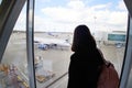 A young girl at the airport looks out the window waiting for her flight. Royalty Free Stock Photo